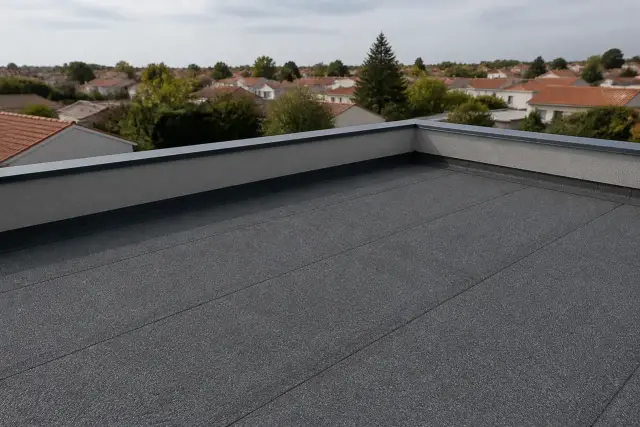 Acrotère en béton au bord d’une toiture-terrasse, avec relevé d’étanchéité et couvertine métallique