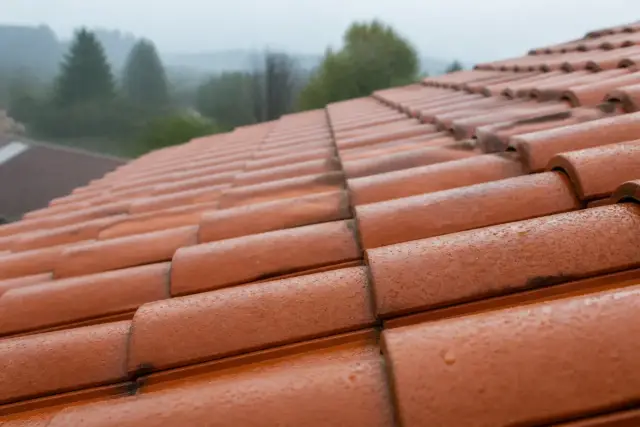 Tuiles en terre cuite propres et sèches après traitement, gouttes de pluie perlant à leur surface