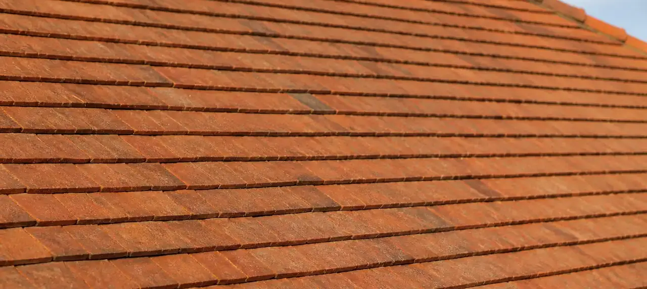 Rangs de tuiles plates de terre cuite vus de près, pureau régulier