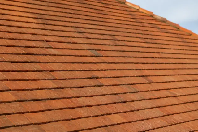 Rangs de tuiles plates de terre cuite vus de près, pureau régulier