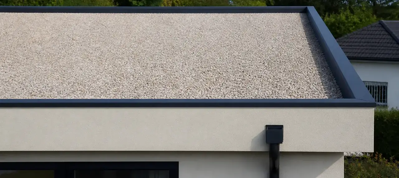 Maison contemporaine à toit plat bordé d’un acrotère, protection en gravillons