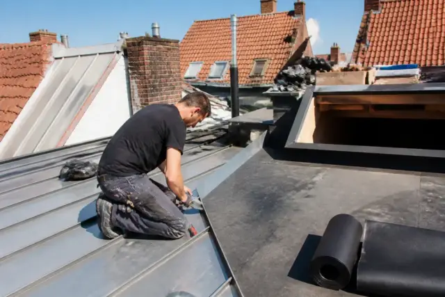 Ouvrier rénove une toiture à Bruxelles pour tousrenov.be avec des matériaux modernes et durables