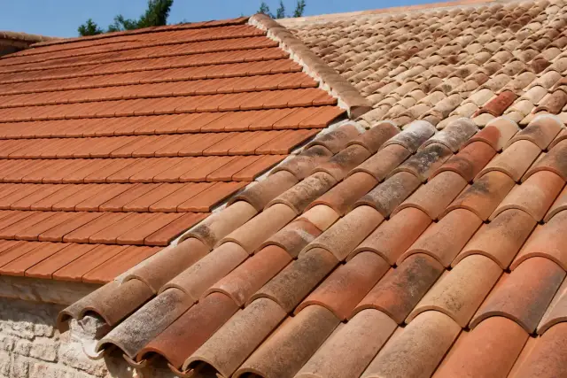 Toits en pente illustrant une variété de tuiles en terre cuite rouges et brunes
